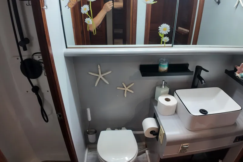 Slide: The Image of 1987 Viking Gulfstar bathroom with modern sink, starfish decor, and floral mirror accents. - 43