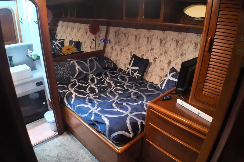 Slide: The Image of Cozy bedroom in 1987 Viking Gulfstar yacht with nautical-themed bedding and adjacent bathroom. - 47