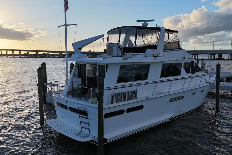 Slide: The Image of 1987 Viking Gulfstar yacht docked at sunset, with bridge and water in the background. - 6
