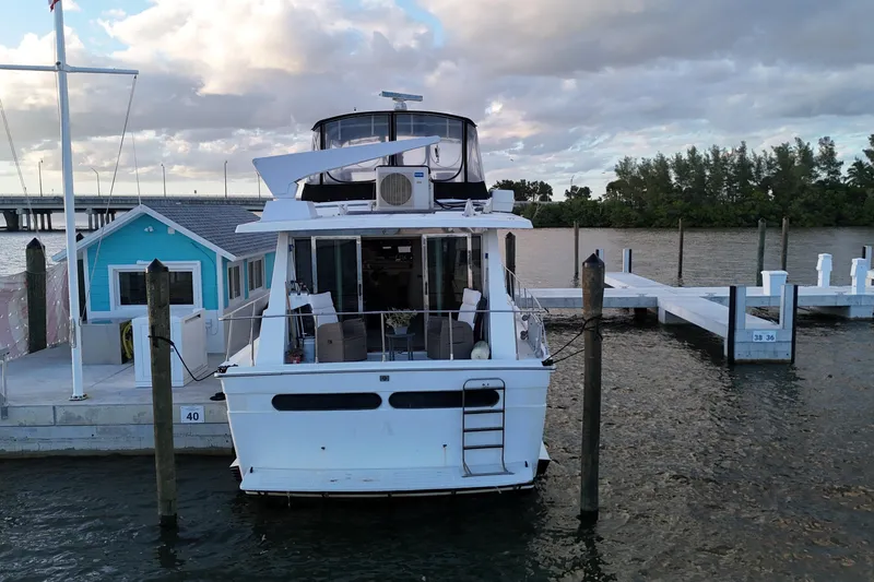 Slide: The Image of 1987 Viking Gulfstar yacht docked at marina, surrounded by calm waters and cloudy sky. - 7