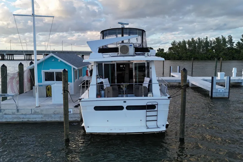 Slide: The Image of 1987 Viking Gulfstar yacht docked at marina with blue building and scenic waterway. - 9