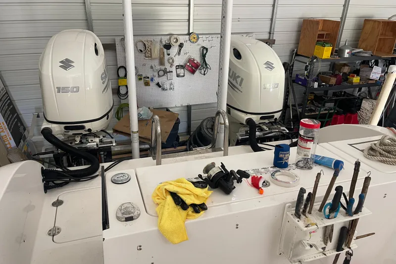 Slide: The Image of 2020 Twin Vee 230 JP CC boat with Suzuki 150 engines in a garage workshop. - 3