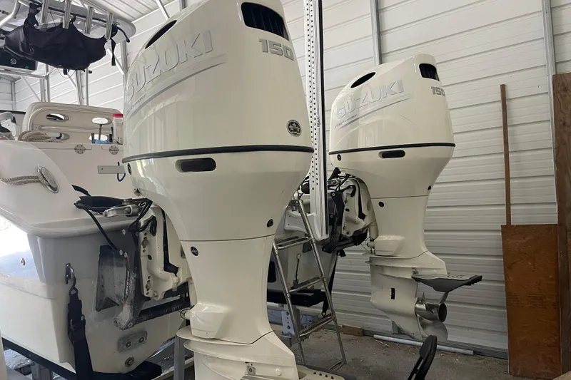 Slide: The Image of Twin Vee 230 JP CC 2020 with dual Suzuki 150 outboard motors in a garage. - 4