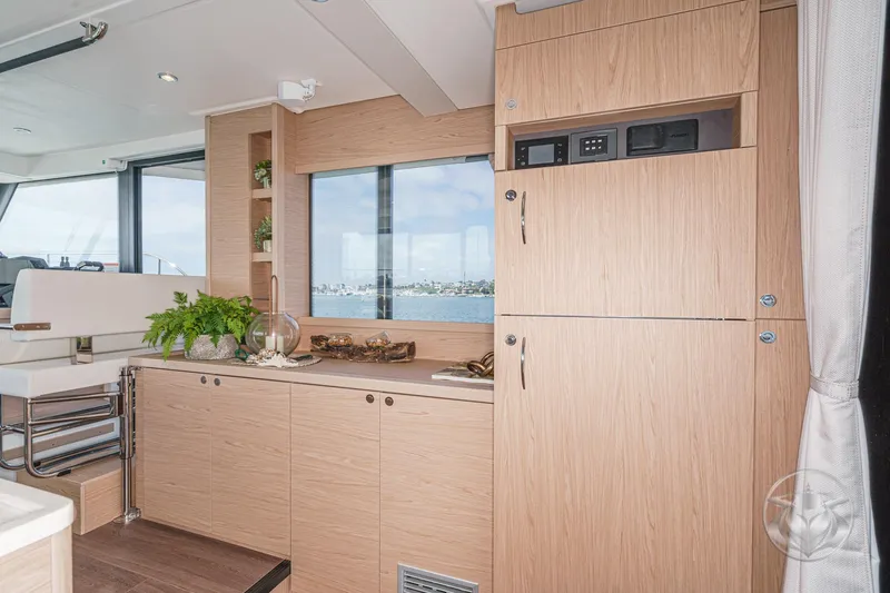 Slide: The Image of Interior of 2026 Beneteau Swift Trawler 41 Fly with modern wood cabinetry and scenic window view. - 49