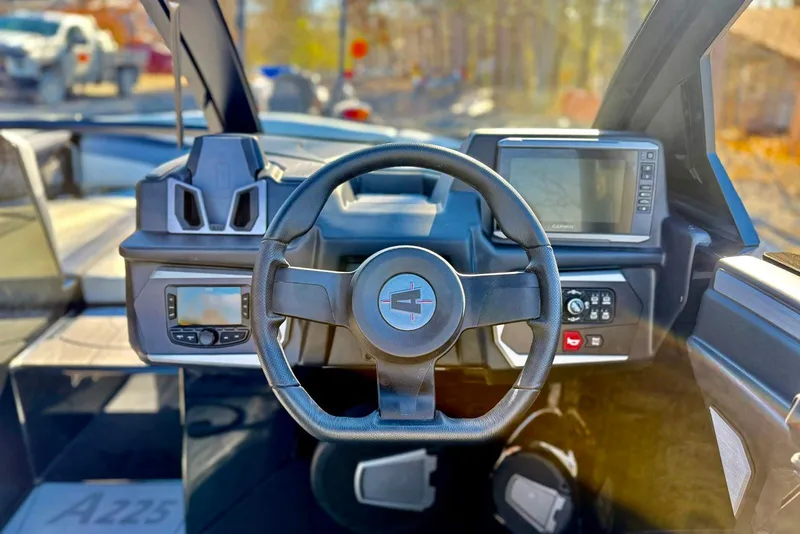 Slide: The Image of Steering wheel and dashboard of 2025 Axis A225 boat with modern controls and displays. - 6