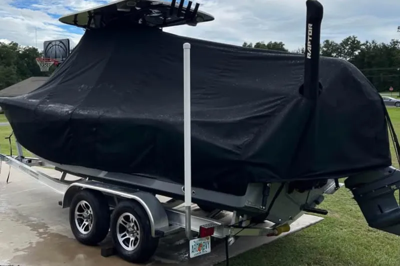Slide: The Image of 2022 NauticStar 2302 Legacy boat covered on trailer, parked outdoors. - 6
