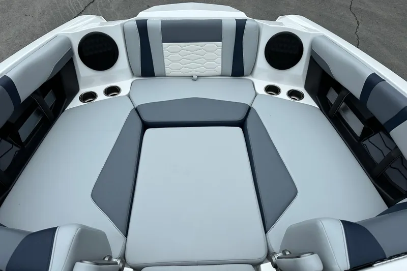 Slide: The Image of 2025 Malibu Wakesetter 22 MXZ interior with gray and white seating, cup holders, and speakers. - 7