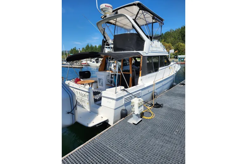 The Image of 1992 Bayliner 3288 Motoryacht docked at marina under clear blue sky. - 0