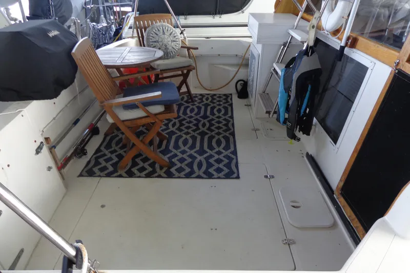 Slide: The Image of 1992 Bayliner 3288 Motoryacht interior with wooden chairs, table, and patterned rug. - 12