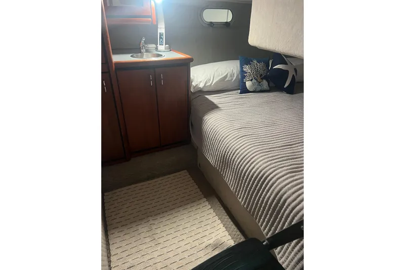 Slide: The Image of Cozy cabin interior of 1992 Bayliner 3288 Motoryacht with bed, sink, and nautical decor. - 23