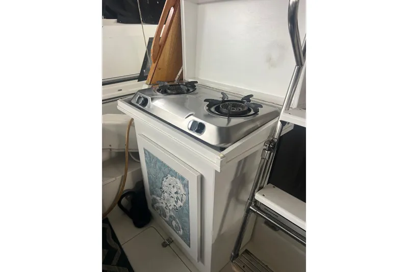 Slide: The Image of 1992 Bayliner 3288 Motoryacht kitchen with dual-burner stove and decorative panel. - 24