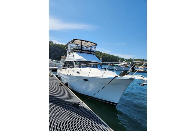 Slide: The Image of 1992 Bayliner 3288 Motoryacht docked in a marina under a covered shelter. - 3