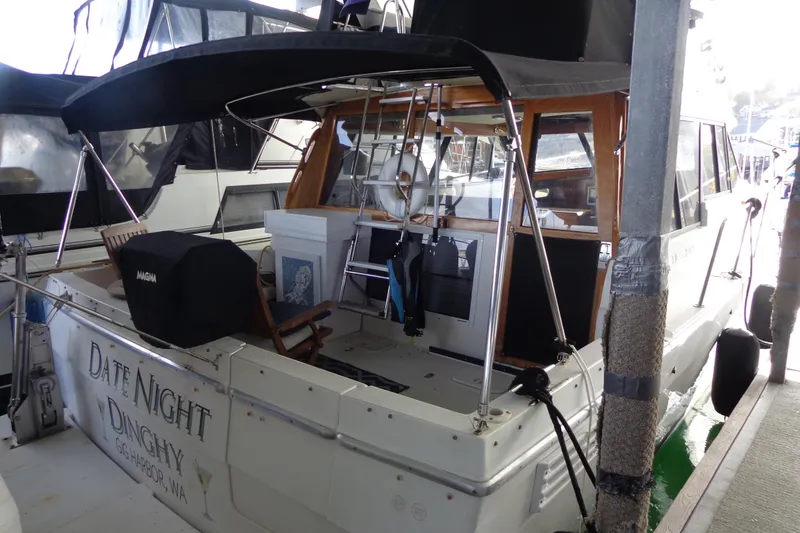 Slide: The Image of 1992 Bayliner 3288 Motoryacht docked, featuring covered deck and seating area. - 6