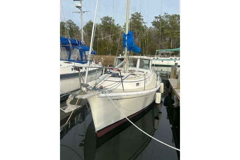 The Image of 1986 Cape Dory MS300 sailboat docked in a marina, surrounded by trees. - 0