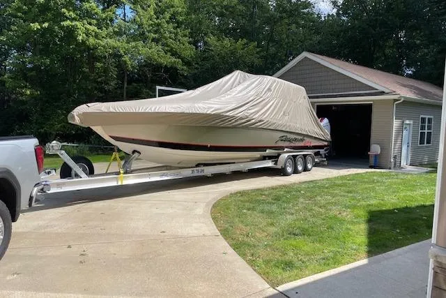 Slide: The Image of 2023 Renegade 38 GTS Open boat on trailer, covered, near garage. - 10