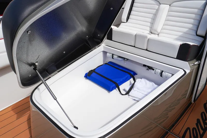 Slide: The Image of 2023 Renegade 38 GTS Open boat storage compartment with blue bag and towel. - 35