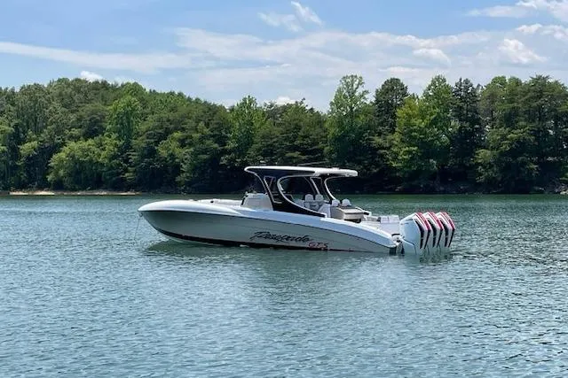 Slide: The Image of 2023 Renegade 38 GTS Open boat on a serene lake with forest backdrop. - 9