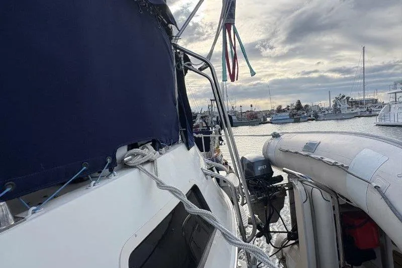 Slide: The Image of 1987 Tollycraft 34 Sundeck Motor Yacht docked, featuring a blue canopy and inflatable dinghy. - 13