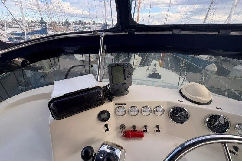 Slide: The Image of 1987 Tollycraft 34 Sundeck Motor Yacht helm with navigation instruments and marina view. - 22