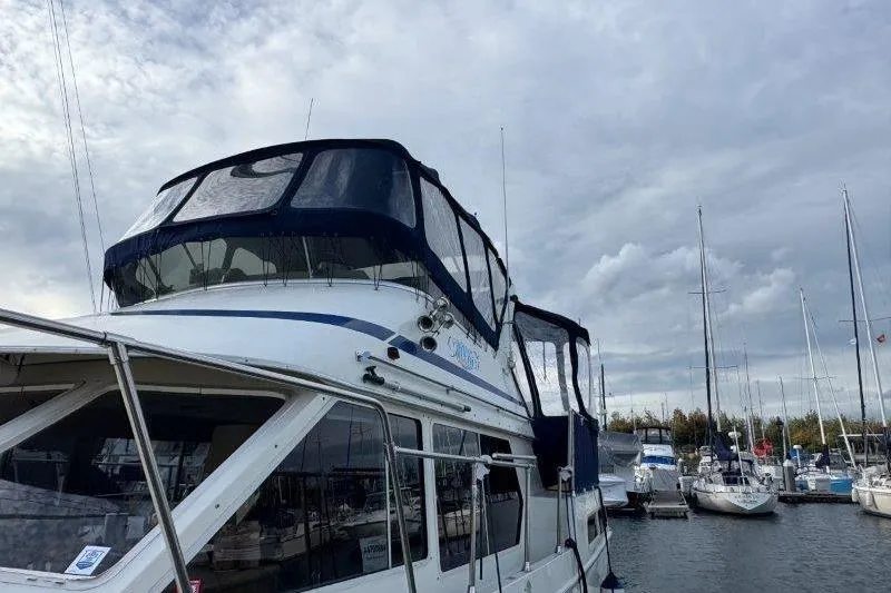 Slide: The Image of 1987 Tollycraft 34 Sundeck Motor Yacht docked at marina under cloudy sky. - 3