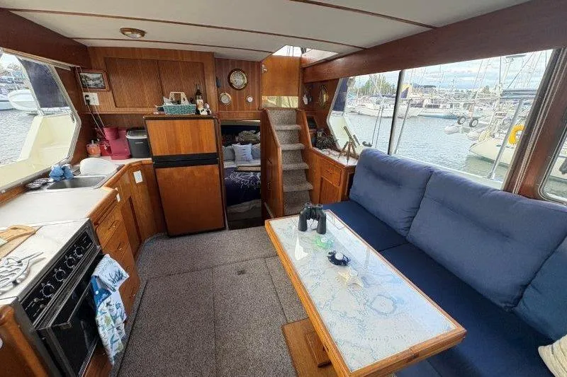 Slide: The Image of 1987 Tollycraft 34 Sundeck Motor Yacht interior with kitchen, seating, and marina view. - 35
