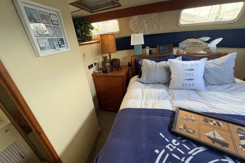 Slide: The Image of 1987 Tollycraft 34 Sundeck Motor Yacht bedroom with nautical decor and cozy bedding. - 40