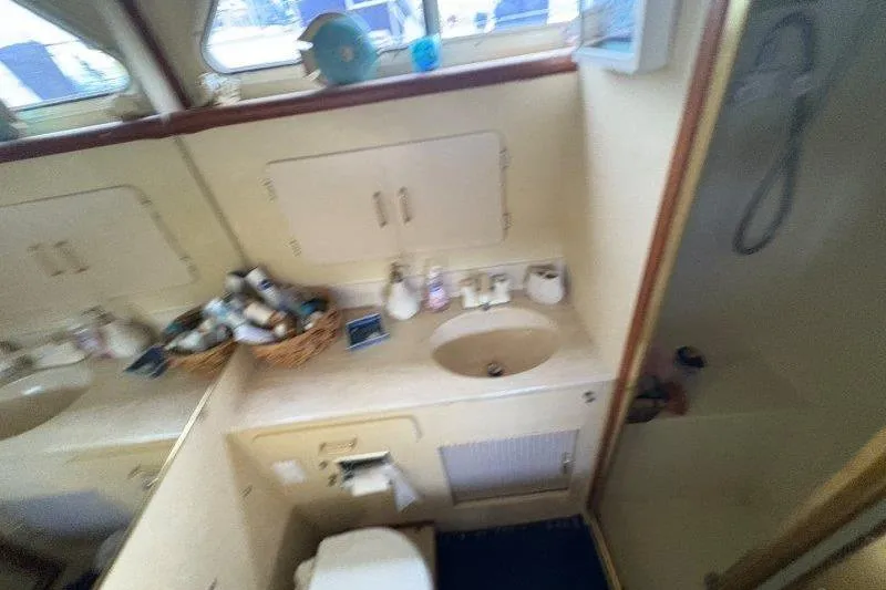Slide: The Image of 1987 Tollycraft 34 Sundeck Motor Yacht bathroom with sink, shower, and toiletries. - 46