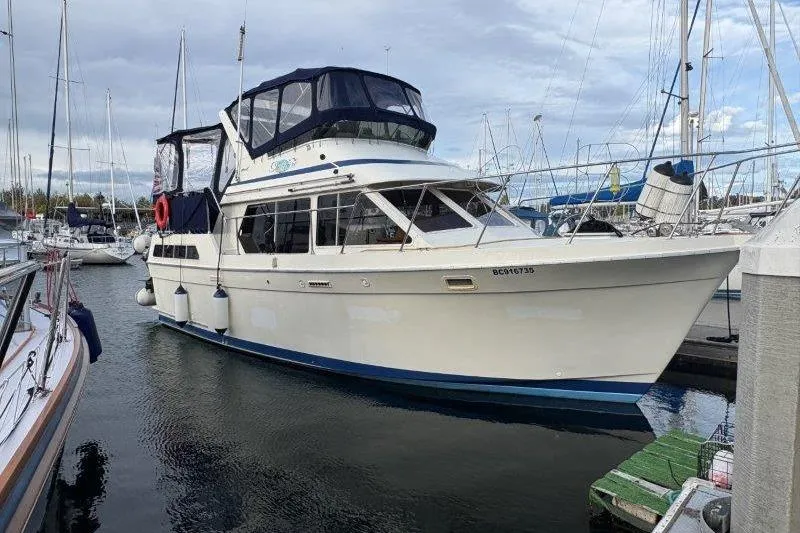 Slide: The Image of 1987 Tollycraft 34 Sundeck Motor Yacht docked in a marina, surrounded by other boats. - 5