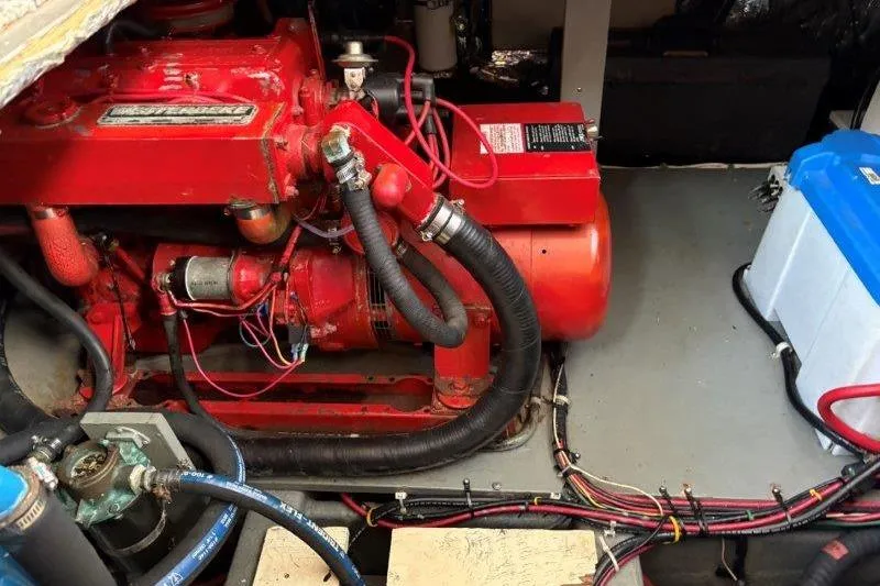 Slide: The Image of Engine room of 1987 Tollycraft 34 Sundeck Motor Yacht with red machinery and cables. - 53