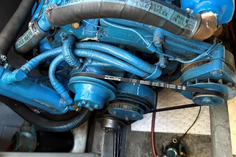 Slide: The Image of Engine of 1987 Tollycraft 34 Sundeck Motor Yacht, featuring blue components and belts. - 58