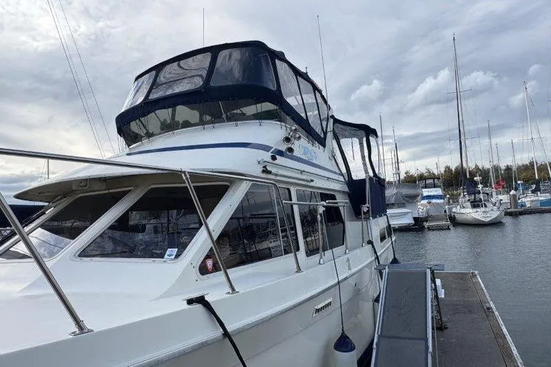 Slide: The Image of 1987 Tollycraft 34 Sundeck Motor Yacht docked at a marina under cloudy skies. - 6
