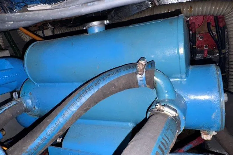 Slide: The Image of Engine compartment of a 1987 Tollycraft 34 Sundeck Motor Yacht with blue hoses and components. - 60