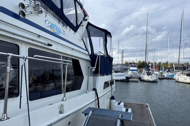 Slide: The Image of 1987 Tollycraft 34 Sundeck Motor Yacht docked in a marina, overcast sky. - 8