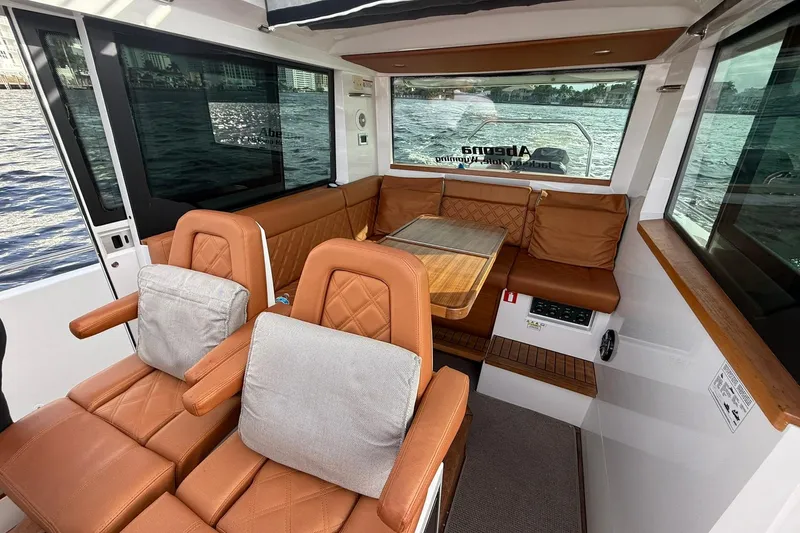 Slide: The Image of 2018 Axopar 37 Sport Cabin interior with brown leather seating and wooden accents. - 5