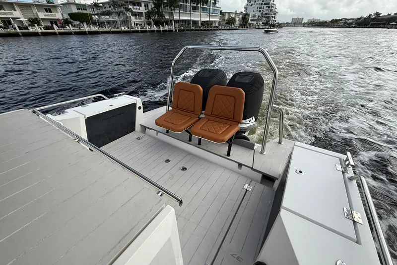 Slide: The Image of 2018 Axopar 37 Sport Cabin boat with dual seats and outboard motors on a waterway. - 6