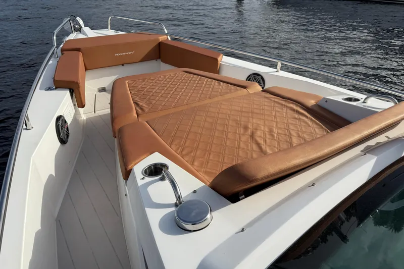 Slide: The Image of 2018 Axopar 37 Sport Cabin with tan leather seating on deck, docked on water. - 7