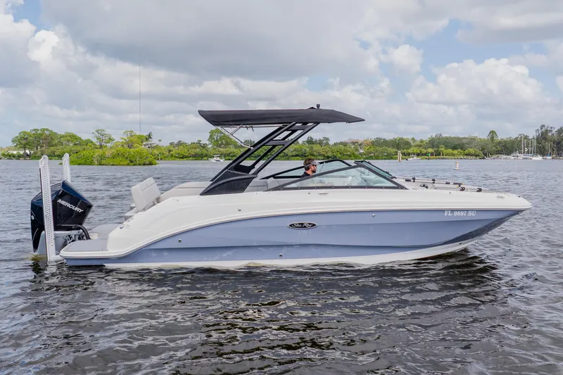The Image of 2021 Sea Ray SDX 250 Outboard boat cruising on a calm lake under a cloudy sky. - 0