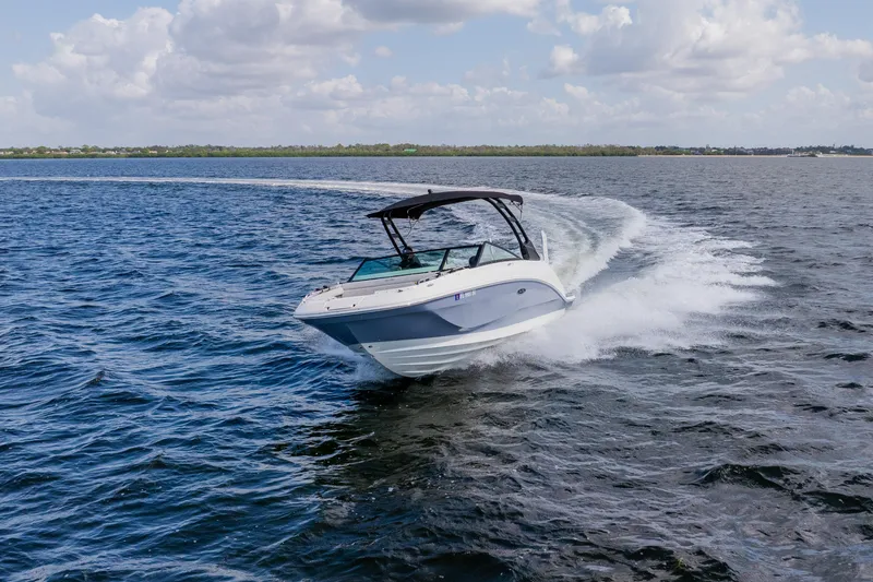 Slide: The Image of 2021 Sea Ray SDX 250 Outboard cruising on open water under a cloudy sky. - 19