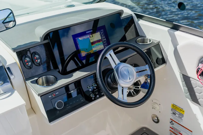 Slide: The Image of 2021 Sea Ray SDX 250 Outboard dashboard with steering wheel and navigation display. - 40