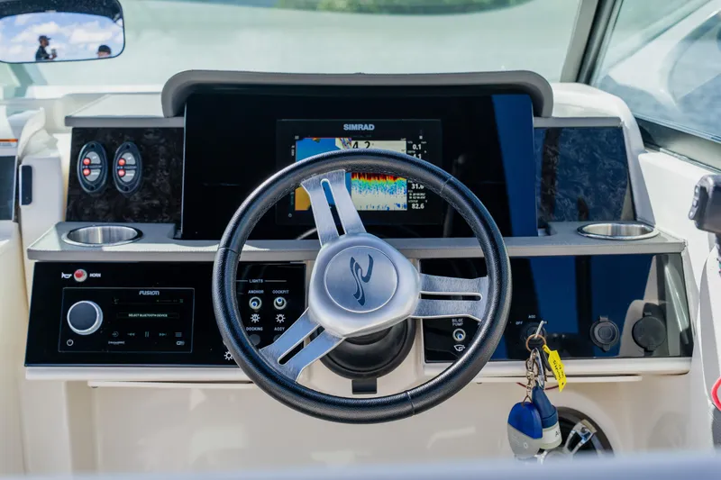 Slide: The Image of 2021 Sea Ray SDX 250 Outboard dashboard with steering wheel and navigation display. - 42