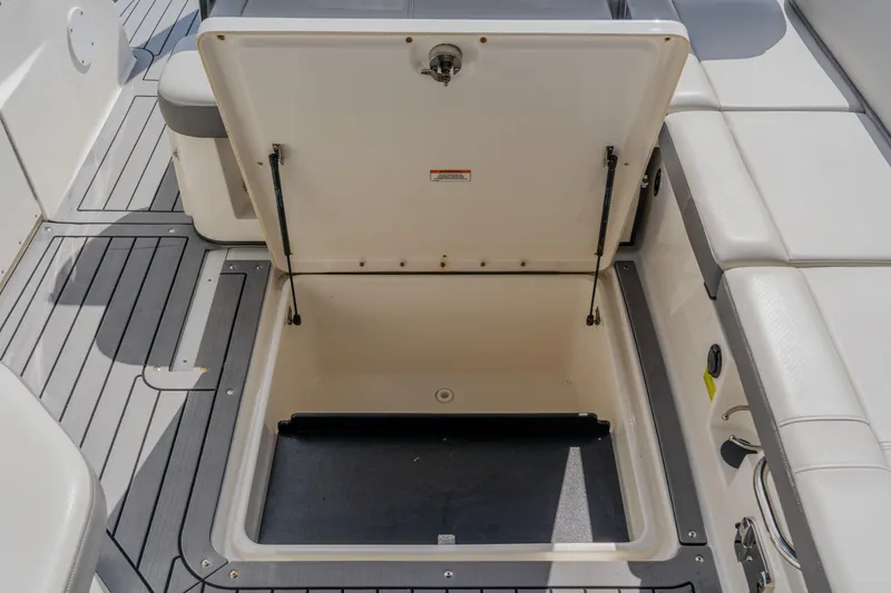 Slide: The Image of 2021 Sea Ray SDX 250 Outboard storage compartment open on deck. - 60