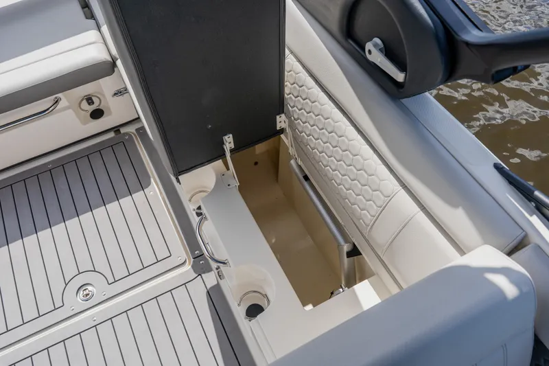 Slide: The Image of 2021 Sea Ray SDX 250 Outboard boat interior storage compartment with cushioned seating. - 65
