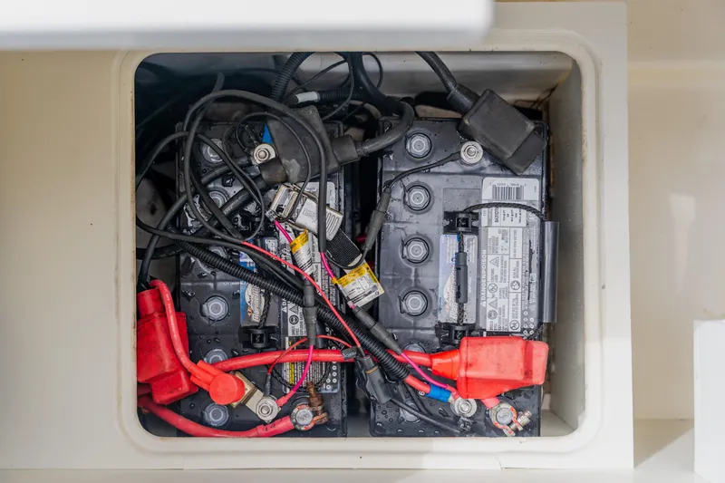 Slide: The Image of Battery compartment of 2021 Sea Ray SDX 250 Outboard with cables and connections. - 75