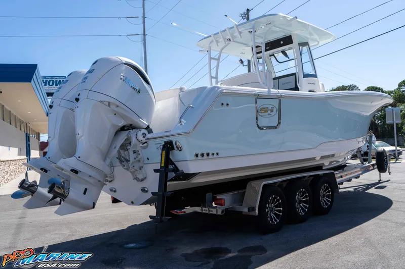 Slide: The Image of 2026 Sea Hunt Ultra 305 Coffin Box boat on trailer, featuring dual engines. - 12