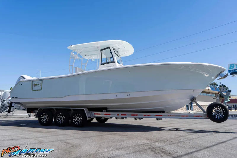 Slide: The Image of 2026 Sea Hunt Ultra 305 Coffin Box boat on trailer under clear blue sky. - 13