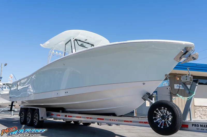 Slide: The Image of 2026 Sea Hunt Ultra 305 Coffin Box boat on trailer, displayed outdoors under clear blue sky. - 14