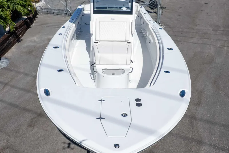 Slide: The Image of 2026 Sea Hunt Ultra 305 Coffin Box boat, white exterior, docked on concrete surface. - 16