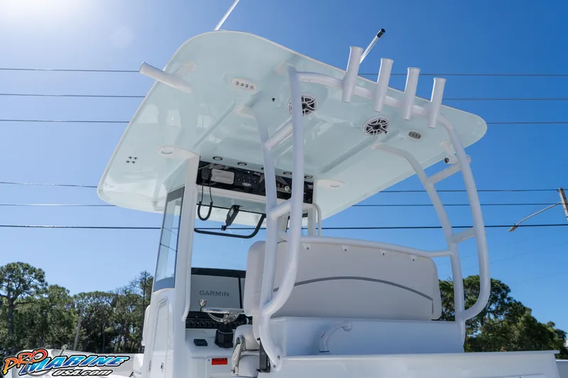 Slide: The Image of 2026 Sea Hunt Ultra 305 Coffin Box boat with T-top and rod holders under clear sky. - 22