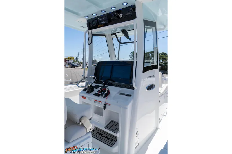 Slide: The Image of 2026 Sea Hunt Ultra 305 Coffin Box boat console with steering wheel and controls. - 25