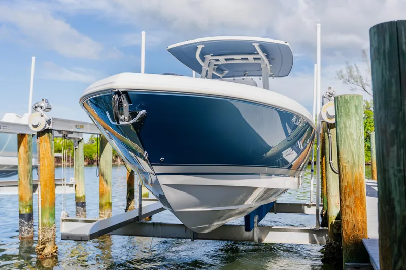 Slide: The Image of 2018 Intrepid 327 Center Console boat on lift at marina dock. - 105